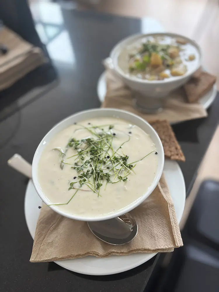 Marienkirchblick Bistro: Zwei Schüsseln Suppen, garniert mit Sprossen und serviert mit Brot.