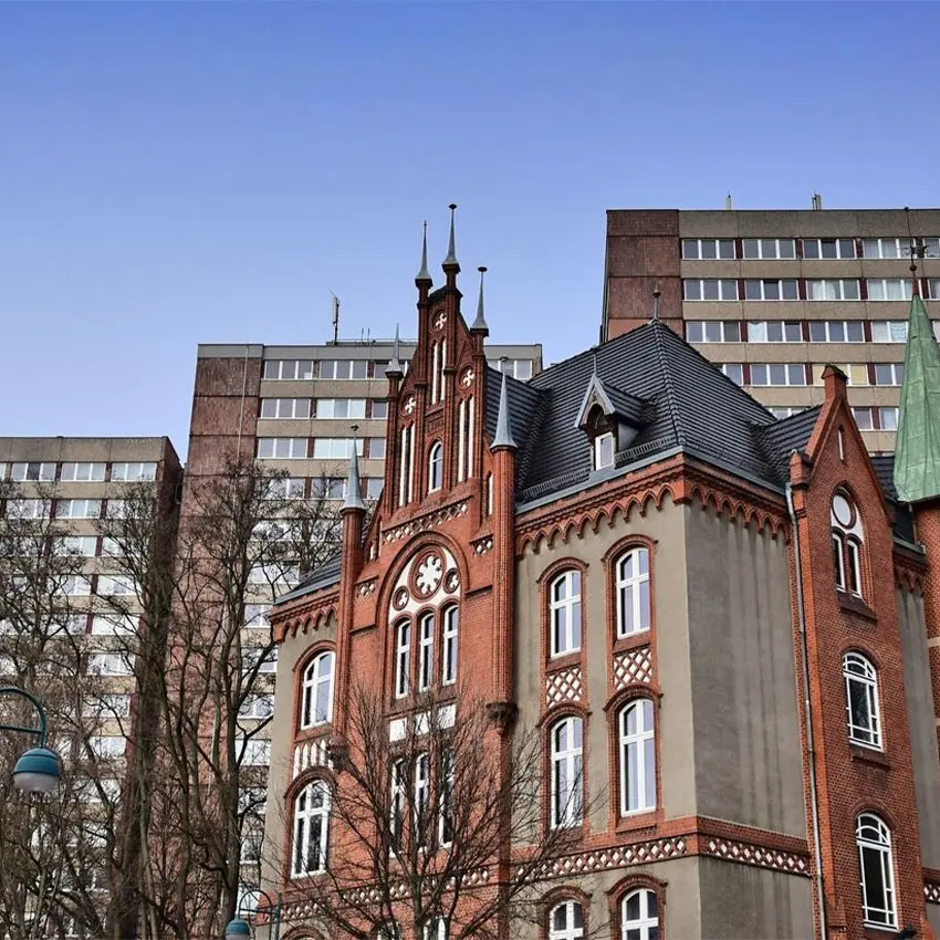 WOWI-FFO-Frankfurt-Oder-Allgemein-1 Architektur: Backsteingebäude mit Türmchen vor Hochhäusern.