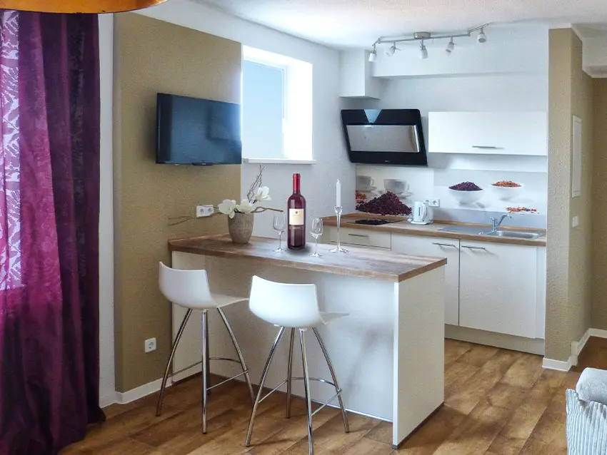 WOWI-FFO-Frankfurt-Oder-Moebliertes-Wohnen-11 WOWI Möbliertes Wohnen: Küche mit Bar, Stühlen, TV und Dekoration.