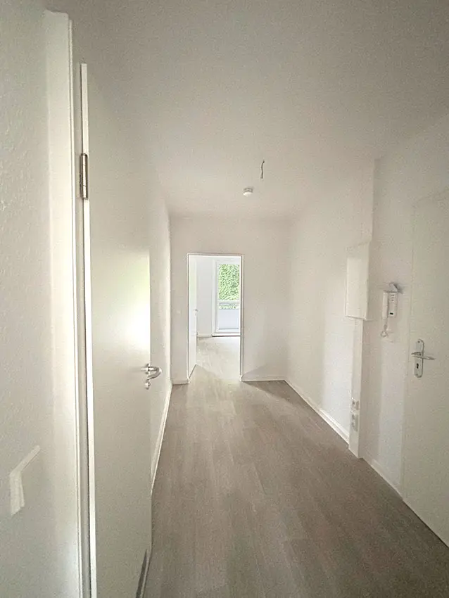 WOWI-FFO-Juri-Gagarin-Ring-16-Innen-1 Innenaufnahme Juri-Gagarin-Ring: Flur mit hellem Laminatboden und weißen Wänden.