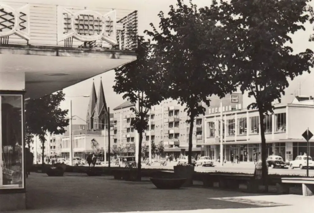 Historische Straßenansicht mit alten Autos und einer Kirche im Hintergrund für WOWI-Geschichten