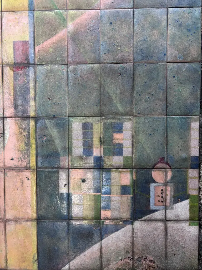 Quadratische Keramikfliesen mit verwitterten Oberflächen, die geometrische Raster und abstrakte Farbverläufe zeigen
