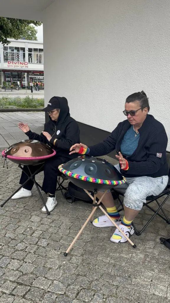 Zwei Personen spielen bei Treppenhausmusik 2027 auf ihren Handpans, die auf Stativen stehen, während sie auf Hockern sitzen
