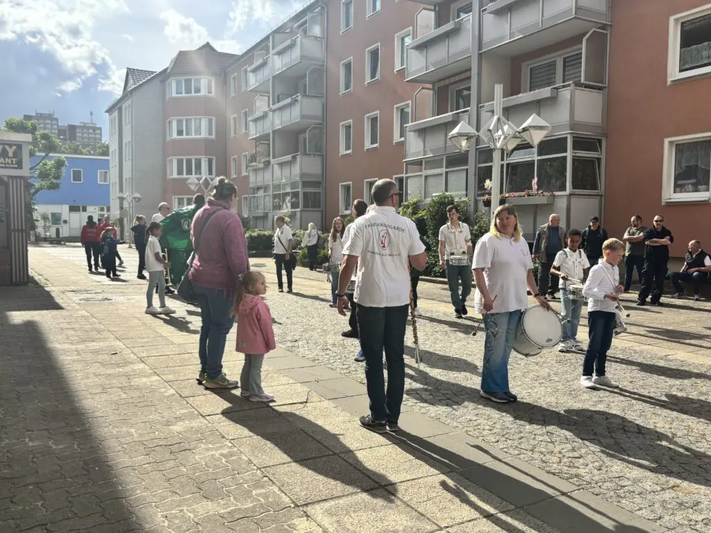 Musikkapelle in weissen T-Shirts bereitet sich bei Treppenhausmusik 2027 auf dem gepflasterten Dorfplatz auf den Auftritt vor