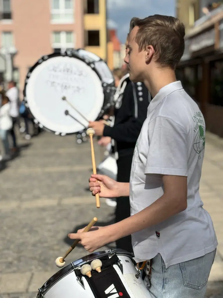Ein junger Trommler in weissem Poloshirt spielt bei Treppenhausmusik 2027 mit Schlegeln auf seiner Marschtrommel