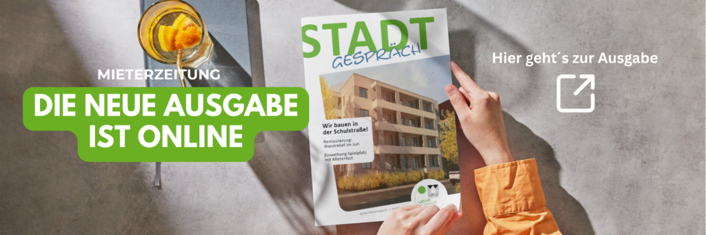 Startseite Mieterzeitung: Hände halten die aktuelle Ausgabe des Stadtgespräch Magazins neben einem Glas mit Getränk.