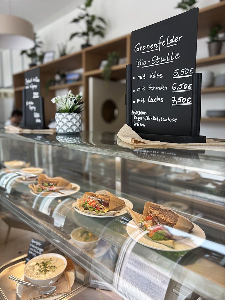 Bistro-Theke mit Stullen unter Glas, Menütafel mit Bio-Stulle Preisen.