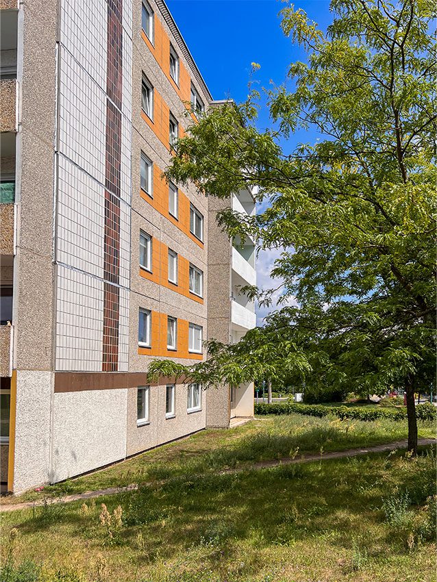 WOWI FFO Stadtteil Neuberesinchen: Fassade eines Wohnhauses mit Grünfläche und Baum.