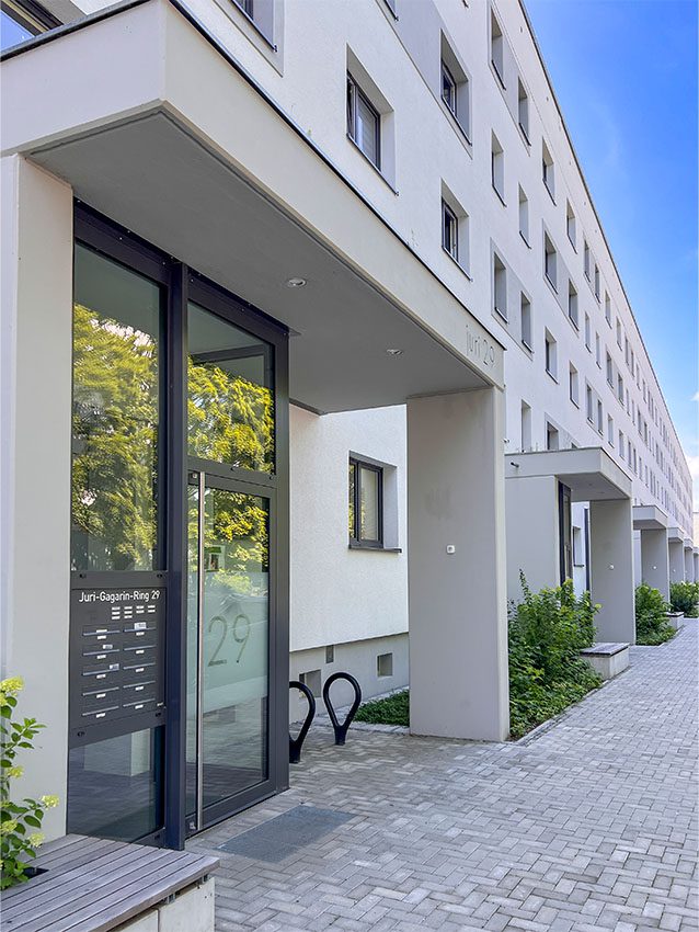 Eingangsbereich eines Wohnhauses, Juri-Gagarin-Ring 29, mit Briefkästen und Fahrradständer.