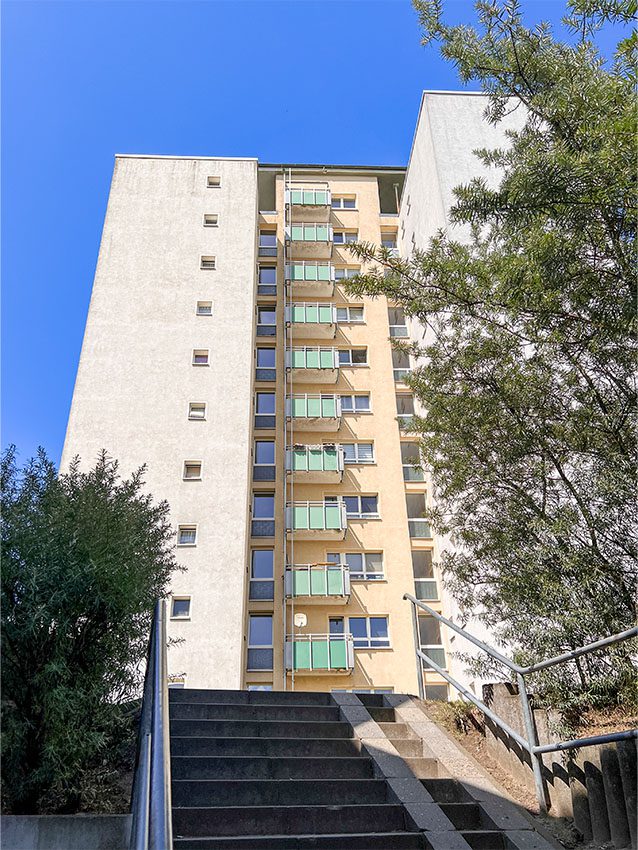 Hochhaus mit Balkonen und Treppe im Vordergrund. Wohngebäude.