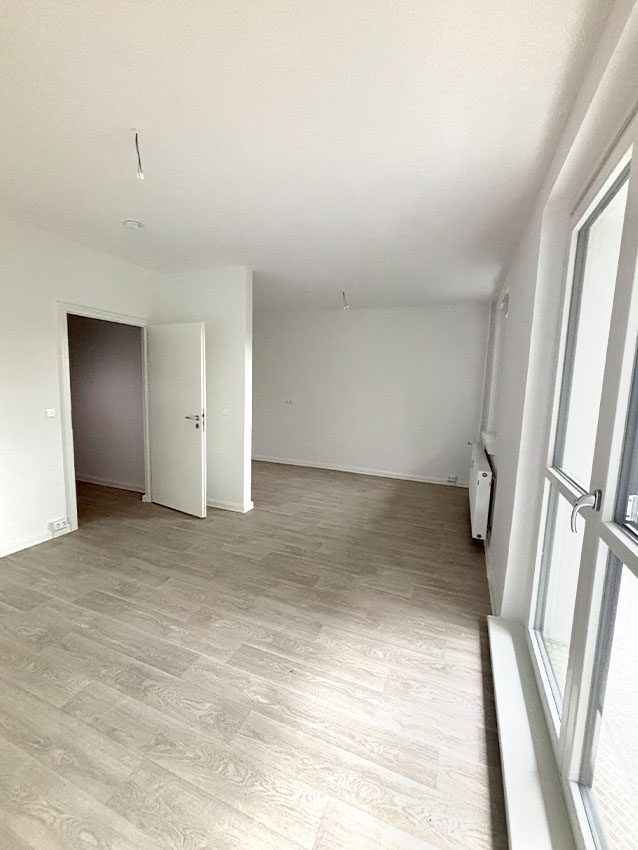 WOWI-FFO Juri-Gagarin-Ring: Innenansicht einer hellen, leeren Wohnung mit Laminatboden und Fenster.