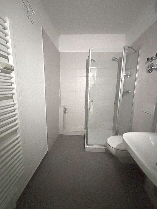 WOWI Juri-Gagarin-Ring: Innenansicht Badezimmer mit Dusche, Waschbecken und Heizkörper. Wohnzukunft Bad.