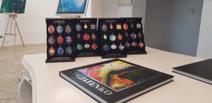 Wander-Atelier der Talente: Schmuckanhänger und Buch "POCZATENKO" aus dem Atelier der Talente ausgestellt