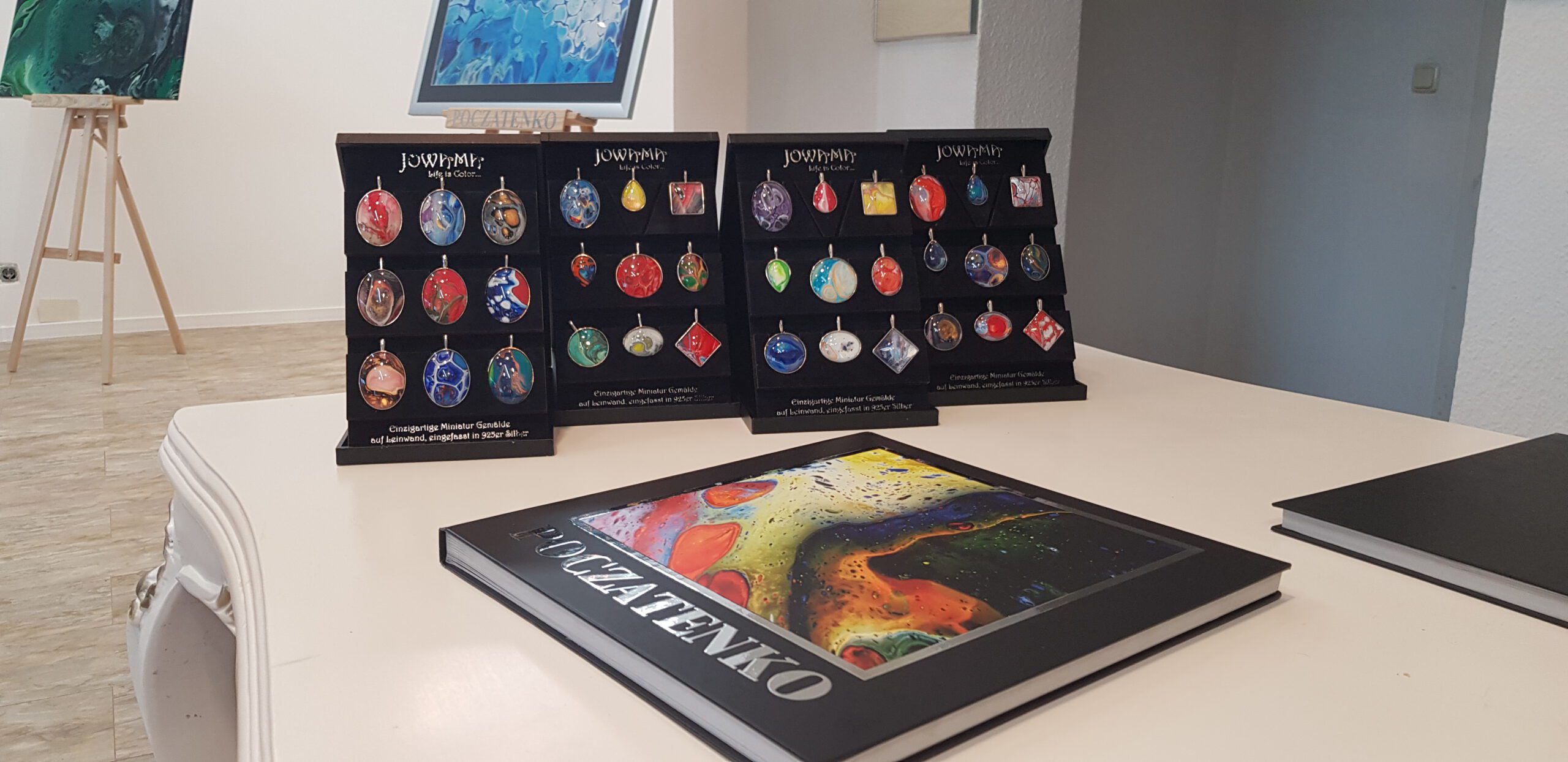 Wander-Atelier der Talente: Schmuckanhänger und Buch "POCZATENKO" aus dem Atelier der Talente ausgestellt